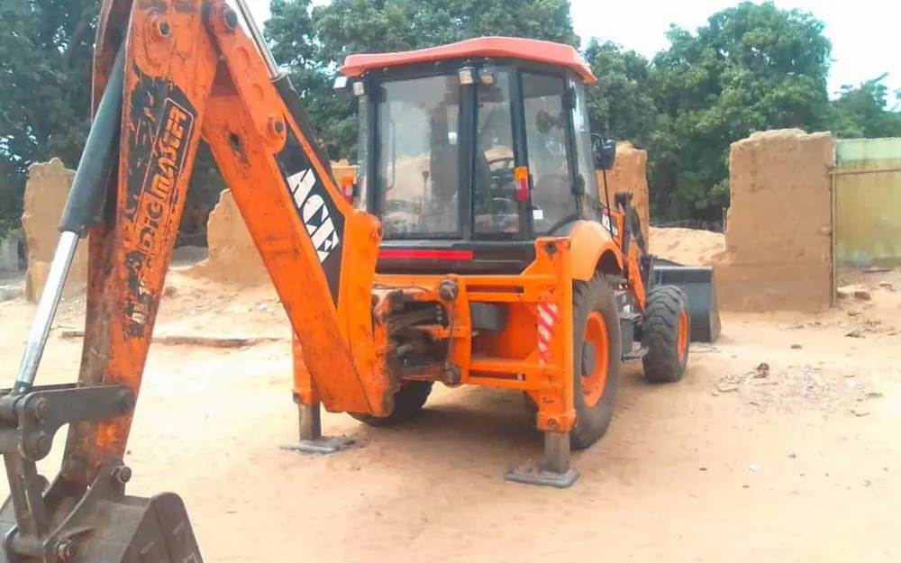 Backhoe loader parked on a sandy site