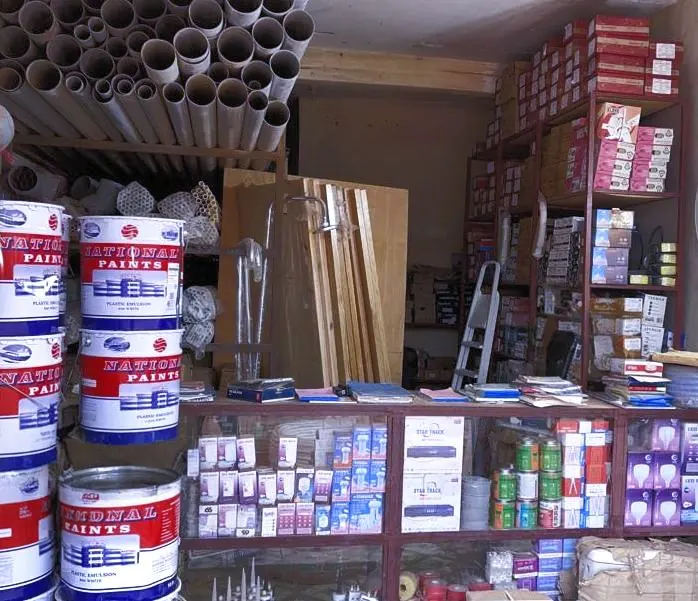 Inside the Sukuta store: paint tins, plywood, pipes and boxed fittings on shelves